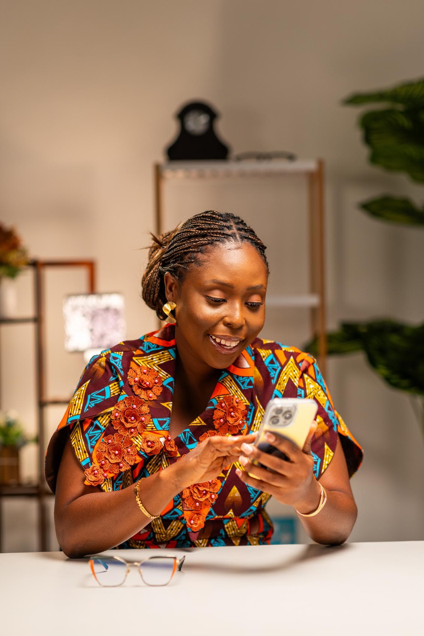 A business owner at home in the evening, checking her business on her phone