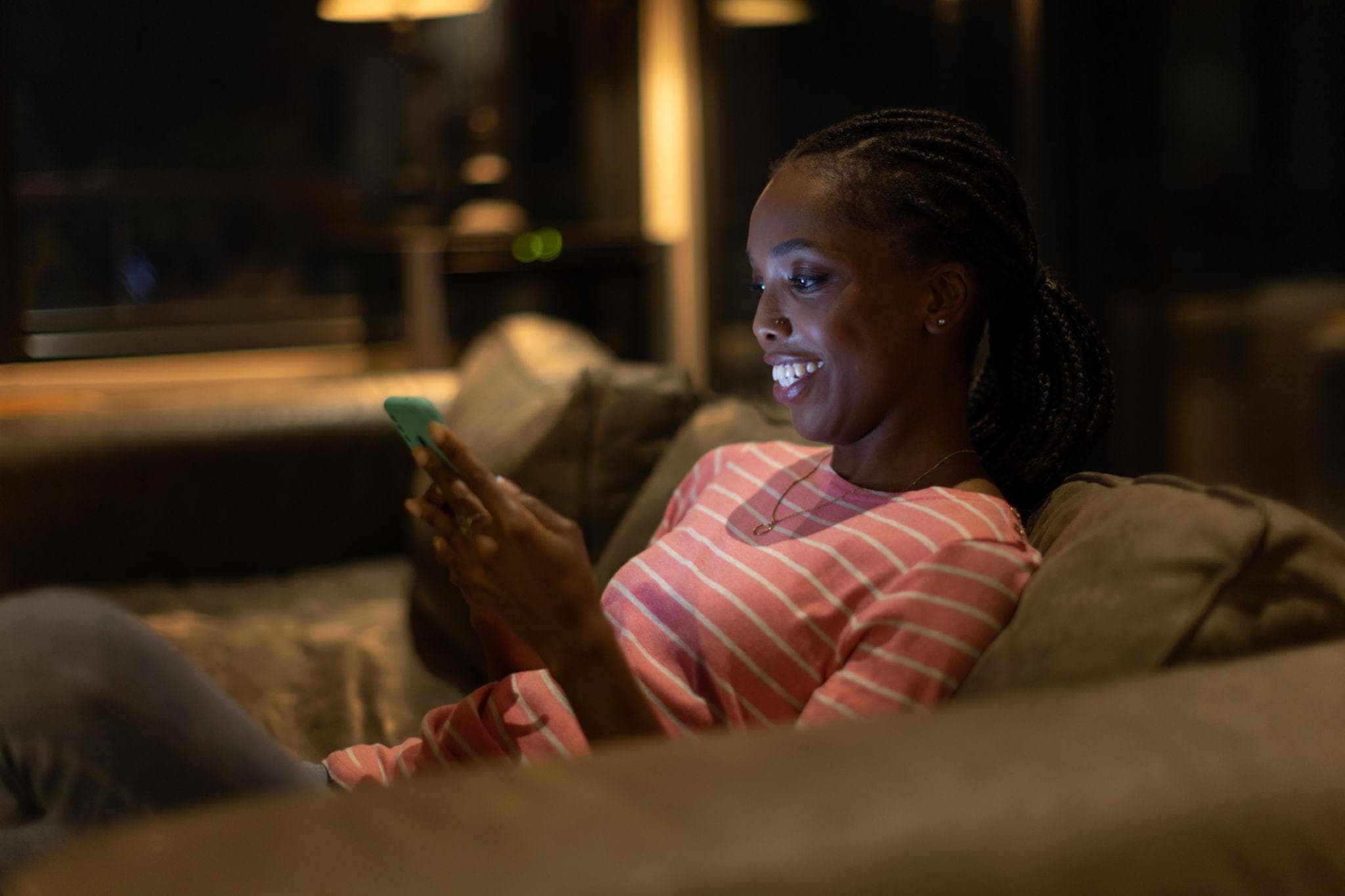 A business owner at home in the evening, checking today's total on her phone
